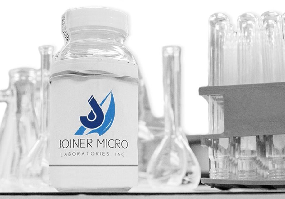 Joiner Micro Laboratories water sample bottle among lab glassware